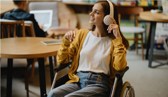 Young woman with headphones who uses a wheelchair